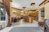 Open-concept kitchen featuring wood cabinetry, stainless steel appliances, a breakfast bar, recessed lighting, and tile flooring
