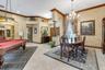 Elegant entertainment spaces featuring a crystal chandelier, formal dining area with wood-finish flooring, and a billiards room with traditional styli