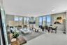 Expansive living area with large format tile flooring, extensive floor-to-ceiling windows, and recessed ceiling lighting