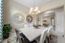 Vaulted ceilings, polished tile flooring, and a multi-arm chandelier with frosted glass shades