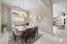 Dining area featuring vaulted ceilings, oversized tile flooring, and a multi-arm chandelier
