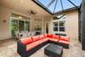 Screened-in patio featuring a vaulted ceiling, stone-finish flooring, ceiling fan, and multi-pane windows