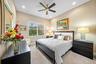 Neutral interior space featuring high ceilings, recessed lighting, a multi-blade ceiling fan, and a large grid-patterned window