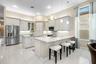 Kitchen featuring light-toned shaker cabinetry, stone countertops, a central island, recessed lighting, and stainless steel appliances
