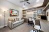 Built-in wood-finish cabinetry, integrated desk workspace, floating shelving, ceiling fan with light fixture, and recessed lighting
