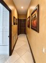 Hallway featuring neutral-toned textured wall finishes, tile flooring laid on a diagonal, recessed ceiling lighting, and solid wood-finish doors with 