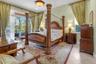 Spacious room featuring tile flooring, textured wall finishes, a decorative central ceiling light fixture, and sliding glass doors providing outdoor a