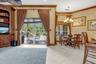 Living area featuring tile flooring, built-in floor-to-ceiling cabinetry, sliding glass doors with exterior access, crown molding, and a multi-light c