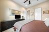 Vaulted ceilings featuring a recessed ceiling fan, neutral wall finishes, carpeted flooring, and bi-fold closet doors