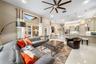 Open-concept living space featuring high ceilings, recessed lighting, expansive picture windows, tile flooring, and kitchen cabinetry with integrated 