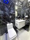 Floor-to-ceiling high-contrast decorative wall tile, white floating vanity, integrated rectangular basin, contemporary low-profile toilet, and rectang