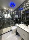 Walk-in shower enclosure with glass panels, full-height dark patterned wall tile, floating vanity with integrated rectangular sink, and recessed ceili