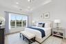 Tray ceiling featuring recessed lighting, large multi-pane windows with exterior water scenery, and wood like flooring