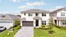 Two-story exterior featuring stone veneer accents, horizontal siding, a tiled roof, and a paved driveway leading to a multi-car garage