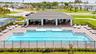 Community swimming pool with paver decking, covered pavilion, metal fencing, and pickleball court.