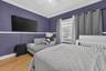 Room featuring wood-finish flooring, white crown molding, crisp white chair rail, and horizontal window blinds