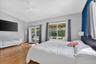 Spacious bedroom featuring vaulted ceilings, wood-finish flooring, and glass French doors