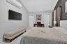 Vaulted ceiling featuring recessed lighting, wall-mounted ductless climate control unit, and crisp white tile flooring