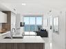 Contemporary kitchen featuring two-tone cabinetry, stone countertops, integrated stainless steel appliances, and polished tile flooring, accented by f
