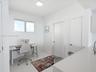 Neutral interior space featuring polished tile flooring, white walls, flush-mount LED ceiling lighting, and a window with a metallic frame