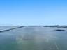 Aerial perspective showcasing expansive water frontage, open horizon, and distant cityscape