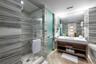 Bathroom featuring floor-to-ceiling stone-tiled walls, a walk-in shower with a glass enclosure, a floating vanity with open shelving, a large wall-mou