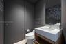 Modern vanity featuring an integrated rectangular sink and stone countertop, wood-finish open cabinetry, wall-mounted faucet, and a wall-to-wall mirro