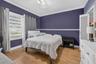 Room featuring wood-finish flooring, crown molding, chair rail trim, and horizontal window blinds
