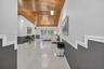 Vaulted wood-plank ceiling, large-format tile flooring, and decorative multi-level chair rail molding