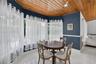 Vaulted wood-plank ceiling, expansive bay of windows, polished tile flooring, and crisp chair rail molding