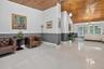 Vaulted wood-plank ceiling, large-format polished tile flooring, two-tone wall treatment with chair rail, and multiple hanging light fixtures