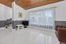 Vaulted wood-plank ceiling, large-format tile flooring, and dual-tone wall treatment with chair rail molding