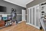 Wood-finish flooring, crown molding, chair rail, bi-fold closet doors with frosted glass panels, and built-in shelving unit