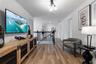 Wood-finish flooring, multi-globe overhead lighting, and metal stair railing with balusters