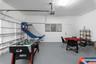 Two-car garage featuring painted walls, smooth-finish concrete flooring, a sectional roll-up door, and an integrated ceiling-mounted garage door opene
