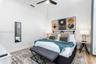 Neutral interior featuring white walls, wood-finish flooring, crown molding, and a ceiling fan with integrated lighting