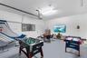 Finished garage space featuring smooth-finish walls, uniform epoxy floor coating, and integrated overhead fluorescent lighting