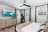 Dual vanity featuring stone countertops, vessel sinks, wall-mounted light fixtures, glass-enclosed shower with tile surround, and frosted glass door