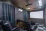 Media room featuring a mounted projection screen, ceiling-mounted digital projector, wall-mounted ductless air conditioning unit, and checkered tile f
