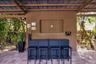 Covered outdoor patio featuring vertical wood-plank siding, stone-paver flooring, and a recessed wall niche