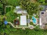 Expansive grounds featuring a swimming pool with integrated spa, multi-sport court, dedicated pickleball court, turf soccer area, and stone-paver walk
