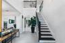 Two-story foyer featuring porcelain tile flooring, a staircase with dark-finished treads and balusters, and a balcony overlook