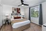 Bedroom featuring wood-finish flooring, a multi-pane window, and a matte black ceiling fan with an integrated light fixture