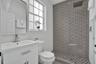 Bathroom featuring a white vanity cabinet with a rectangular basin, patterned geometric tilework in the walk-in shower, recessed ceiling-mounted showe