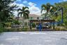 Sand volleyball court featuring a perimeter net and established palm trees, showcasing a two-story exterior with a covered pergola and masonry patio