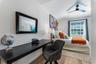 Wood-finish flooring, ceiling fan with integrated lighting, and window with muntins