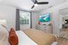Bedroom featuring a ceiling fan with integrated light, wood-finish flooring, and a single-hung window with horizontal blinds