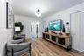 Wood-finish flooring, multi-globe chandelier, and white louvered-style closet doors
