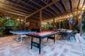 Covered outdoor patio featuring paver flooring, structural wood-beam framing, and integrated string lighting