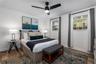 Wood-finish flooring, dual windows with multi-pane glass, and a modern matte black ceiling fan with integrated lighting